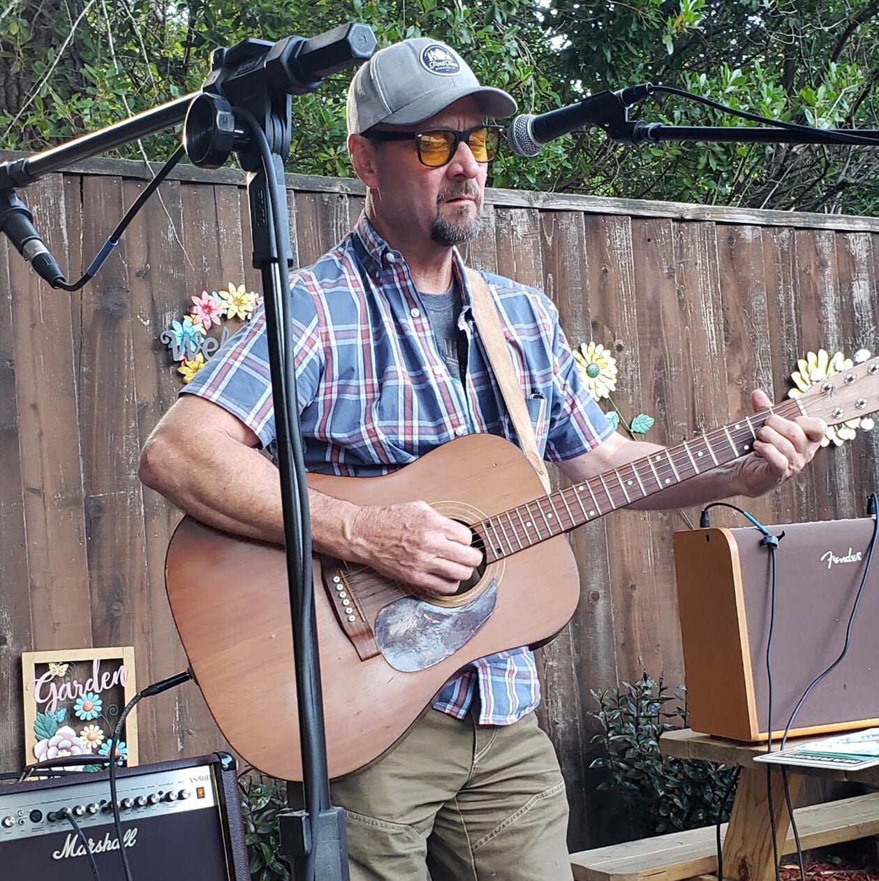 Photo of Jim Foley playing a Martin guitar on at backyard stage